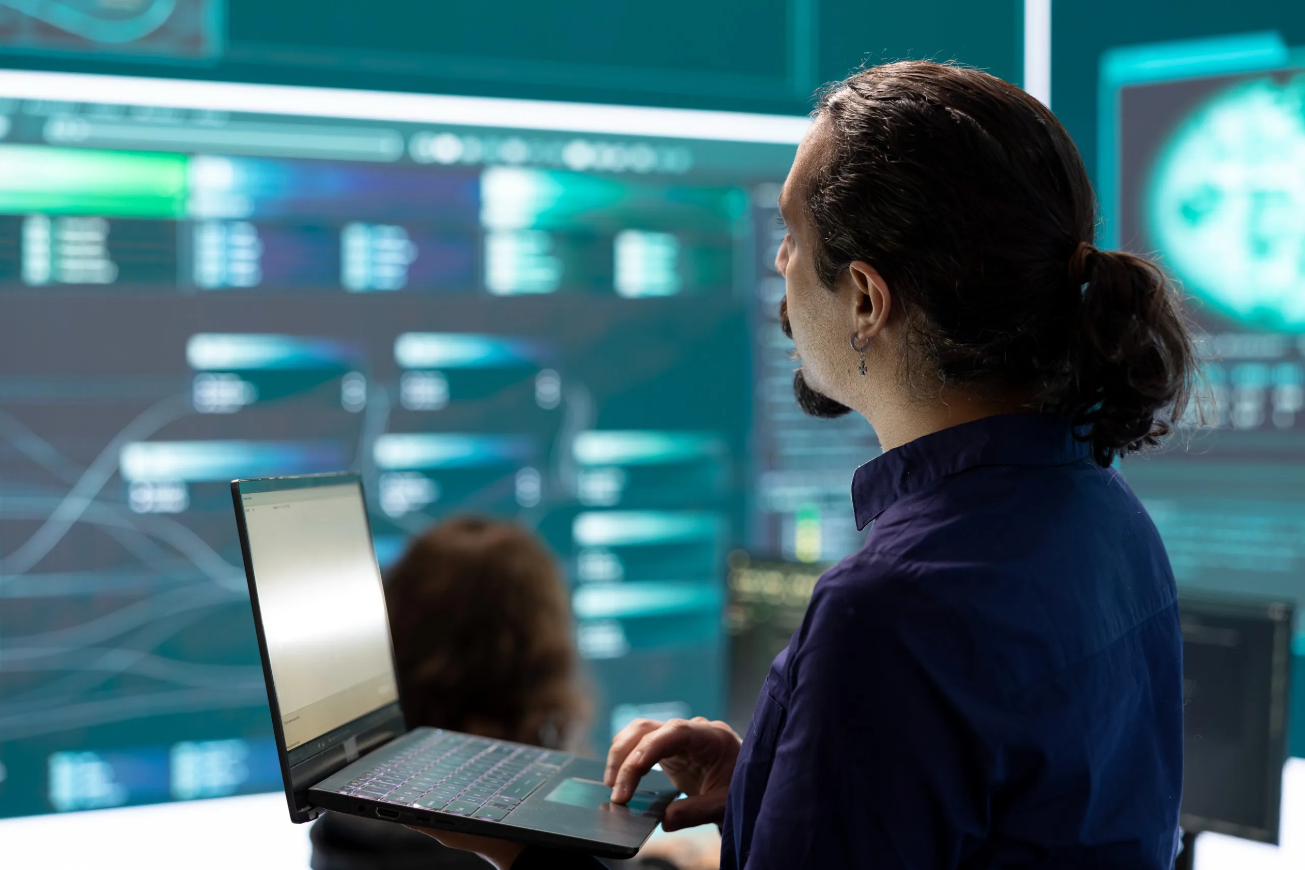 Intelligence as Infrastructure - person with laptop and data displays